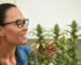 Happy woman with cannabis bush at home, growing cannabis indoors, culture of growing cannabis at